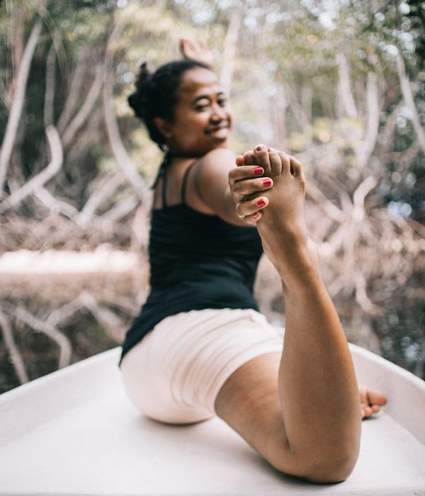 Woman performing a gentle stretching exercise in a serene environment.